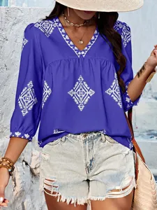 Nahaufnahme der blauen Boho-Bluse mit V-Ausschnitt, weißem Geometrie-Print und 3/4-Ärmeln