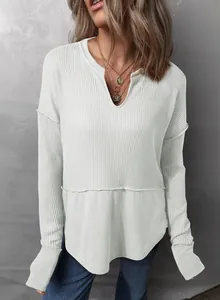 Detalle de sudadera blanca de punto gofrado con cuello en V y un ajuste muy holgado