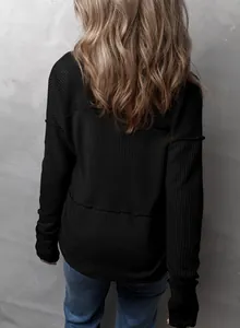 Vista posterior detallada de una sudadera negra para mujer con retazos de punto gofre.