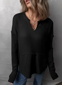 Detalle de una blusa informal negra de manga larga con punto gofrado y diseño de cuello en V