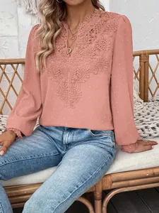 Detail of dusty pink V-neck blouse featuring intricate lace and Swiss dot texture