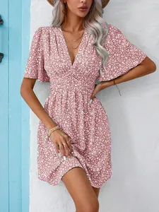 Close-up detail of a pink floral V-neck dress with high waist and flutter sleeves for summer