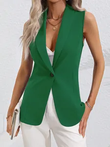 Detail showing the green sleeveless blazer with a sharp lapel and single button closure.