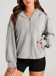 Detailed view of women's light grey oversized half-zip hoodie featuring front pocket and hood