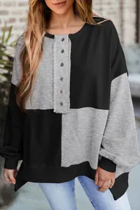 Close-up of women's color-block sweatshirt with button-down collar and fleece texture.