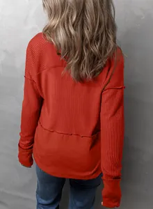 Vista trasera detallada de una sudadera naranja de punto de nido de abeja con paneles