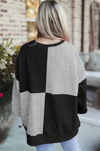 Back view of casual oversized black and grey color block sweatshirt with ribbed hem