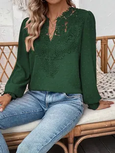 Close-up showing detail of elegant green V-neck blouse with intricate lace crochet