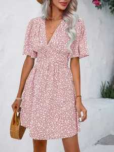 Detail view of pink floral V-neck dress with high waist and puff sleeves.