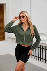 Λεπτομέρεια ενός κομψού πράσινου cropped hoodie με φερμουάρ, κουκούλα και ρυθμιζόμενο κορδόνι.