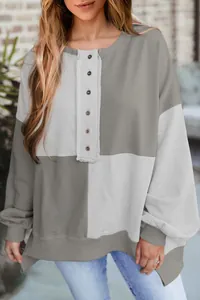 Close-up detail of casual color-block sweatshirt with stylish button-up henley collar.