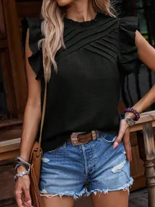 Detalle de blusa negra con mangas con volantes plisados y cuello cruzado