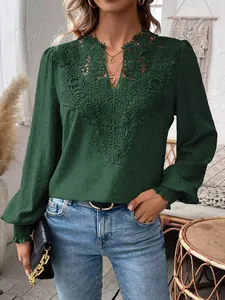 Macro view of dark green long sleeve blouse featuring intricate V-neck lace embroidery work