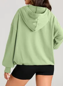 Back view of a comfortable light green oversized hooded sweatshirt with long sleeves for women