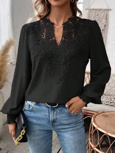 Detailed view of women's black V-neck lace blouse with Swiss dot fabric and long sleeves.