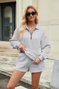 Detailansicht des hellgrauen Zweiteilers mit Sweatshirt mit halbem Reißverschluss und Shorts.
