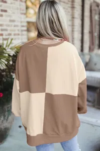 Back view of women's oversized color block sweatshirt in brown and cream beige tones.