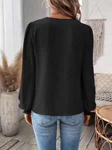 Rear view of black long sleeve Swiss dot blouse in a cozy home setting