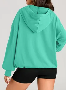 Detailed back view of a mint green oversized hoodie for women, made from soft fleece fabric.