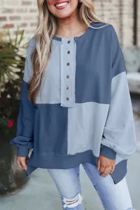 Detailed view of women's oversized color-block henley sweatshirt featuring a button-up collar