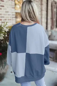 Detailed back view of a casual color-block patchwork sweatshirt in shades of blue