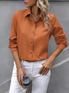 Détail d'une chemise orange à manches longues avec boutons et col classique pour femme