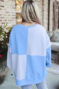 Back view of a casual women's color-block sweatshirt featuring blue and lavender panels.