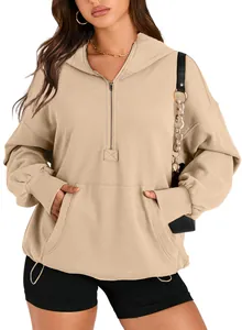 Close-up detail of the half-zip collar and front pocket on a beige women's hooded sweatshirt