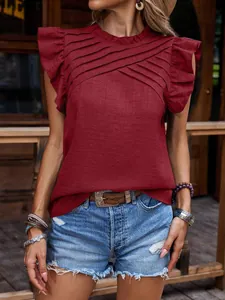 Primer plano del elegante frente plisado y las mangas con volantes de una blusa roja.