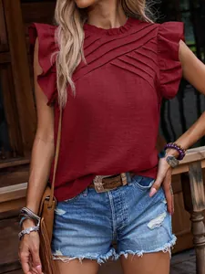 Top rojo vino con pliegues y mangas con volantes usado por modelo en exteriores