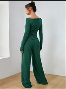Vista posteriore di una donna che indossa un completo verde scuro con maglia e pantaloni