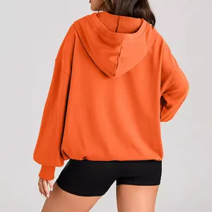 Stylish back view of women's oversized orange long sleeve drawstring hoodie sweatshirt.