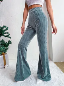 Full view of light blue ribbed velvet flare pants showing the fit and high waist.