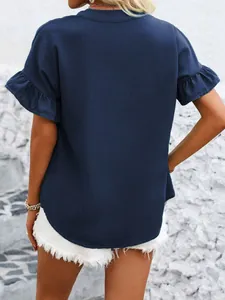 Vista posteriore di una blusa in cotone blu navy con maniche a volant e bottoni sul collo