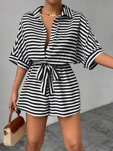 Detail of striped short romper featuring lapel, buttons, and matching waist belt.