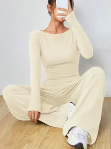 Dettaglio del set da donna con top beige a maniche lunghe e pantaloni coordinati a gamba larga
