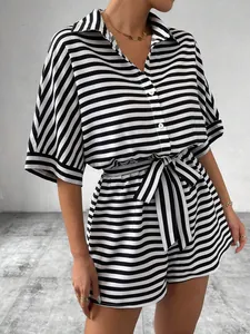 Close-up of black and white striped romper showing button detail and belted waist