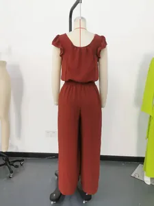 Back view of a brick-red wide-leg jumpsuit with elastic waist and ruffled sleeves