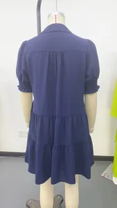 Back view of a navy blue tiered V-neck dress with puffed sleeves and pleated details
