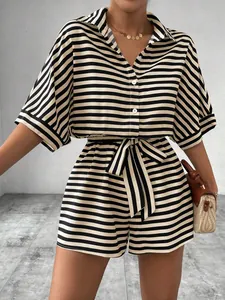 Detail view of women's black and white striped shirt and shorts set with waist belt.