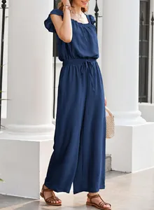 Close-up detail of navy blue square neck jumpsuit with ruffled sleeves and drawstring waist.