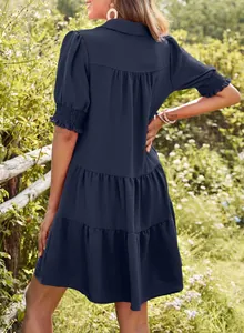 Detailed back view of a navy blue tiered dress with textured fabric and puffed sleeves