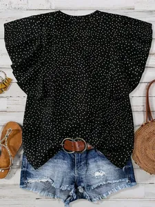 Detailansicht der schwarzen Polka-Dot-Chiffonbluse mit Flattermanschetten und Jeans-Shorts.