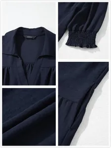 Close-up of navy V-neck pleated dress with elastic ruffle cuffs and textured fabric.