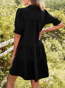 Back view of a black tiered summer dress featuring pleated texture and puff sleeves detail