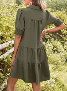 Back view of a dark green pleated tiered dress with short sleeves and lapel collar