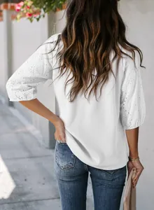 Rückansicht einer weißen Waffelstrickbluse mit eleganten Puffärmeln aus Lochspitze