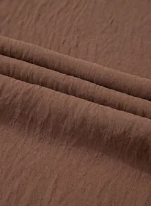 Macro close-up view showing the intricate wrinkled texture of this solid brown jumpsuit fabric.