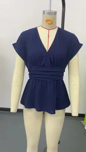 Détail du chemisier bleu marine à col en V, taille plissée et basques évasées