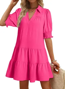 Detail of pink tiered V-neck dress with puff sleeves and textured fabric on model.